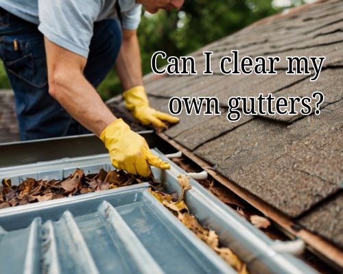 Hands clearing twigs and leaves from a roof gutter