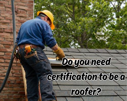 Worker laying shingles on pitched roof.